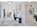 Bright foyer featuring a modern console table, elegant artwork, and open view to the kitchen and living area at 5939 Redbay Blvd, Bradenton, FL 34210