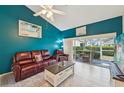 Inviting living room with sliding doors to lanai, plush leather seating, and blue accent wall at 6330 Green Oak Cir, Bradenton, FL 34203