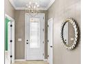 Elegant entryway featuring a decorative glass door, stylish light fixture, and decorative wall mirror at 6713 Chester Trl, Bradenton, FL 34202