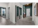 Neutral colored hallway with unique mirror decor, leading to a door and showcasing the neutral color palette at 8134 Shore Lake Dr, Englewood, FL 34224