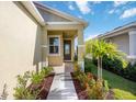 Inviting entrance with landscaped flowerbeds, a walkway and a charming front door at 10455 Wet Marsh Cv, Parrish, FL 34219