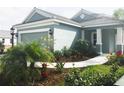 Inviting exterior view with lush landscaping, a winding walkway, and an attached two-car garage at 12676 Sagewood Dr, Venice, FL 34293