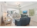 Bright living room with a ceiling fan, an archway to the kitchen, and tile flooring at 12676 Sagewood Dr, Venice, FL 34293