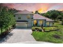 Charming two-story home with lush landscaping, a paver driveway, and a tile roof at 12838 Daisy Pl, Bradenton, FL 34212