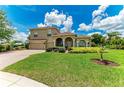 Lovely home featuring a well-maintained lawn, arched entryway, and a two-car garage for a polished curb appeal at 12838 Daisy Pl, Bradenton, FL 34212