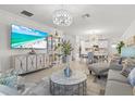 Elegant living room with modern furnishings, decorative lighting, and a view to the dining area at 17576 Holly Well Ave, Wimauma, FL 33598