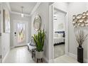 Bright entryway with tile floors, decorative mirror, and plant; a bedroom is just off the foyer at 17578 Holly Well Ave, Wimauma, FL 33598