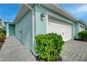 Exterior of villa with a white garage door, stone driveway, and manicured landscaping at 17732 Wayside Bnd, Punta Gorda, FL 33982