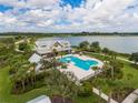 Aerial view of a heart-shaped pool, clubhouse, and lake, surrounded by lush landscaping at 17732 Wayside Bnd, Punta Gorda, FL 33982