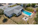 Aerial view of a backyard featuring a pool, fire pit area, and well-maintained landscaping at 2647 Britannia Rd, Sarasota, FL 34231