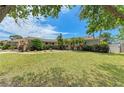Inviting single-story home featuring manicured lawn, mature trees, and colorful landscaping, offering great curb appeal at 2908 Mayflower St, Sarasota, FL 34231