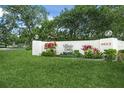 Community sign for Village Oaks, surrounded by lush landscaping and manicured lawn at 314 Oak Hill Way # 24, Sarasota, FL 34232