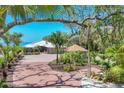 Inviting home with a brick driveway, lush landscaping, and a peek of the bay waters at 3931 Bay Shore Rd, Sarasota, FL 34234