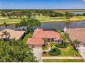 Stunning single-story home boasts water and golf course views with a screened-in lanai at 407 Fieldstone Dr, Venice, FL 34292