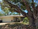 Charming single-story home with mature trees, a two-car garage, and a well-maintained front yard at 4170 Prudence Dr, Sarasota, FL 34235