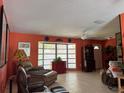 A cozy living room featuring tile flooring, a ceiling fan, and a large bay window at 4170 Prudence Dr, Sarasota, FL 34235