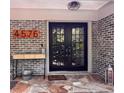 Inviting front entrance featuring a brick facade, decorative console table, and stylish double doors at 4576 Cooper Rd, Sarasota, FL 34232