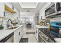 Bright kitchen featuring white cabinets, a stainless steel stove, and subway tile backsplash, for stylish meal preparation at 4741 Watkins Ave, Sarasota, FL 34233