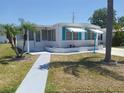 Well maintained home featuring a colorful front yard, awnings, brick planter and sidewalks at 4920 Boca Raton Ave, Sarasota, FL 34234