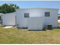 Exterior view of a white home with a shed and an air conditioning unit at 4920 Boca Raton Ave, Sarasota, FL 34234