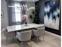 Modern dining room with marble table, grey chairs, statement lighting, and decorative wall art at 4970 Oyster Pearl St, Lakewood Ranch, FL 34211