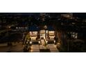 Night aerial view of the modern home with illuminated windows and balconies, surrounded by lush landscaping at 540 S Polk Dr, Sarasota, FL 34236