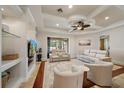 Bright living room featuring a coffered ceiling, a large flat-screen TV, and comfortable seating at 5624 Aaron Ct, Sarasota, FL 34232