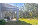 Expansive backyard features a covered patio with dining set, perfect for outdoor entertaining at 5672 Jonesboro Ave, North Port, FL 34288