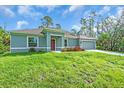 Beautifully landscaped one-story home with a well-manicured lawn, colorful flowers, and an attached two-car garage at 5672 Jonesboro Ave, North Port, FL 34288