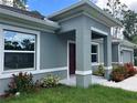 Inviting home exterior featuring a modern design with a covered entrance and colorful, landscaped front yard at 5672 Jonesboro Ave, North Port, FL 34288