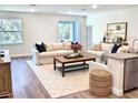 Bright and airy living room featuring hardwood floors, neutral paint, plush couches, and a stylish coffee table at 5672 Jonesboro Ave, North Port, FL 34288