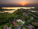 Scenic aerial view of a waterfront community, showcasing lush landscapes and a serene sunset over the water at 6612 Butlers Crest Dr, Bradenton, FL 34203