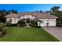 Charming home with manicured lawn, fountain, mature landscaping, brick driveway, and a two-car garage at 6612 Butlers Crest Dr, Bradenton, FL 34203