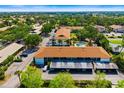 An aerial view shows a multi-unit dwelling, carport parking, lush landscaping, and a community pool at 7201 Curtiss Ave # 2D, Sarasota, FL 34231
