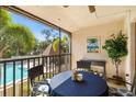 Balcony with table and chairs that overlooks the community pool and lush, tropical landscaping at 7201 Curtiss Ave # 2D, Sarasota, FL 34231