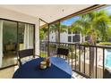 The unit's balcony has a table with seating, overlooks lush landscaping, and has direct access to the unit at 7201 Curtiss Ave # 2D, Sarasota, FL 34231