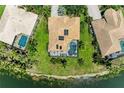Aerial view of home with screened-in pool, well-maintained lawn, and lake frontage at 7574 Camden Harbour Dr, Bradenton, FL 34212