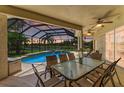 Covered patio featuring outdoor seating and ceiling fans overlooking a screened-in pool and lake at 7574 Camden Harbour Dr, Bradenton, FL 34212