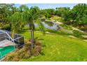 Expansive backyard with a screened lanai, pond view, and lush landscaping at 9101 Yarberry St, Sarasota, FL 34240