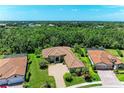 A beautiful aerial view of a home surrounded by lush landscaping and a nature preserve at 9734 Carnoustie Pl, Bradenton, FL 34211