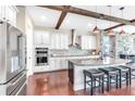 Kitchen with hardwood floors, stainless steel appliances, island with seating and stone accent wall at 13116 Bliss Loop, Bradenton, FL 34211