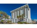 Modern condominium building with white facade and multiple balconies under a clear blue sky at 101 S Gulfstream Ave # 5J, Sarasota, FL 34236