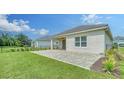A paved outdoor patio and a grassy lawn, perfect for outdoor entertaining and relaxation at 10105 Canaveral Cir, Sarasota, FL 34241