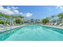Stunning resort-style pool surrounded by palm trees and lounge chairs for ultimate relaxation and enjoyment at 10105 Canaveral Cir, Sarasota, FL 34241