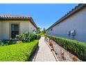 A stone walkway meanders between homes, lined with lush greenery and leading to tranquility and privacy at 10205 Saint Francis Ter, Palmetto, FL 34221