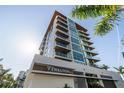 Low angle view of the building's entrance highlighting its modern architectural design and signage at 111 Golden Gate Pt # 802Ph, Sarasota, FL 34236