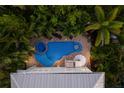 An aerial view captures a stunning pool and spa surrounded by lush tropical landscaping at 113 Maple Ave, Anna Maria, FL 34216