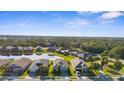Aerial view of a suburban neighborhood with a central lake and mature trees at 12565 Ryegrass Loop, Parrish, FL 34219