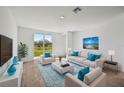 Bright living room with neutral furniture, a blue rug, and sliding glass doors to the backyard at 14061 Crutchfield Ct, Parrish, FL 34219
