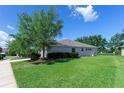 Spacious backyard with lush green grass and mature trees, overlooking a serene pond, perfect for outdoor enjoyment at 14230 Cattle Egret Pl, Lakewood Ranch, FL 34202